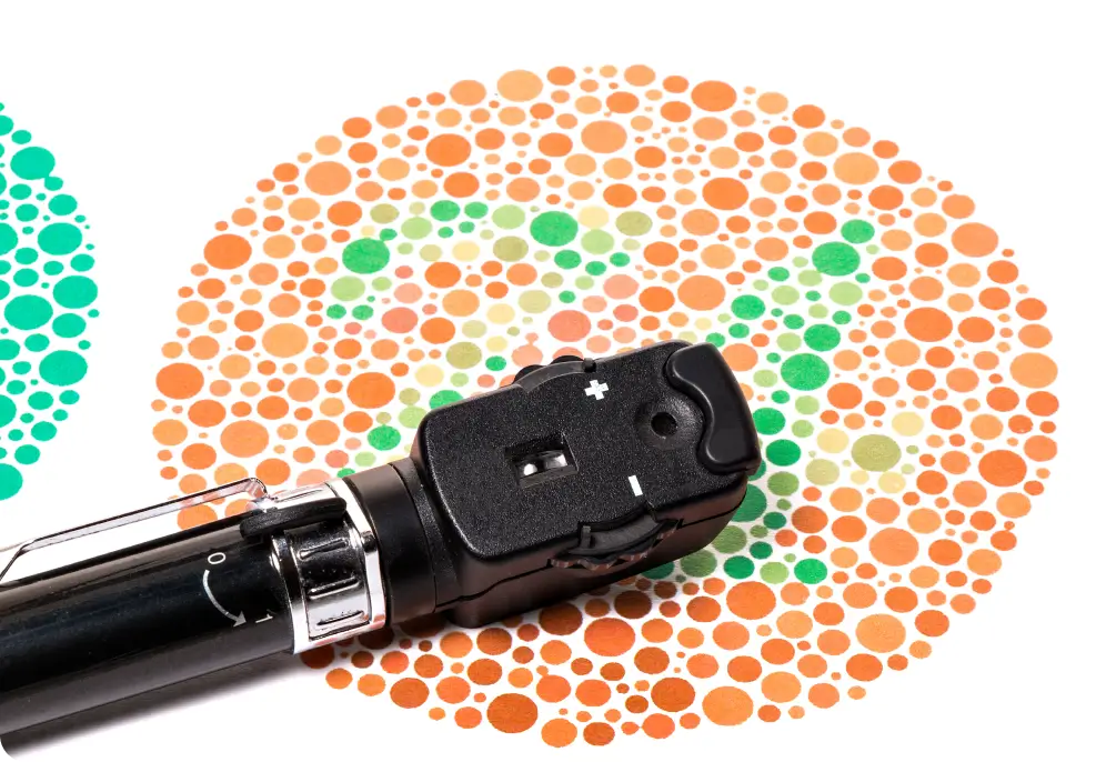 An ophthalmoscope resting on an Ishihara color perception test plate featuring orange and green dots.