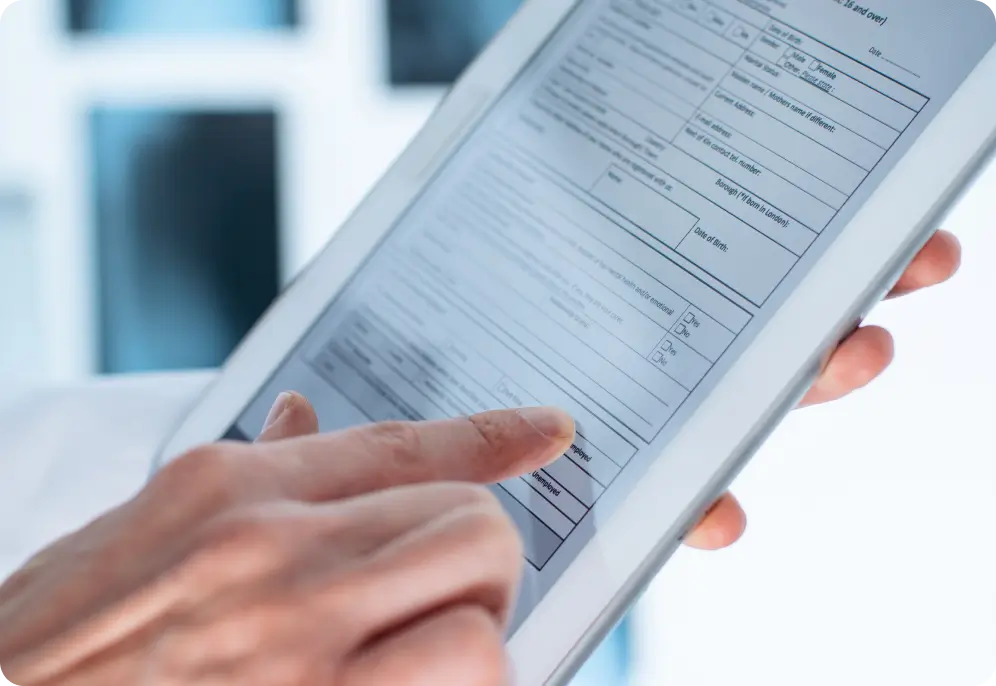 Close-up of a person filling out a digital medical history form on a tablet.